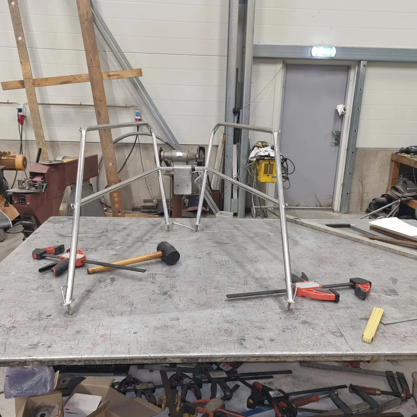 Rostfria pushpit-bågar uppspända på svetsbordet i verkstaden